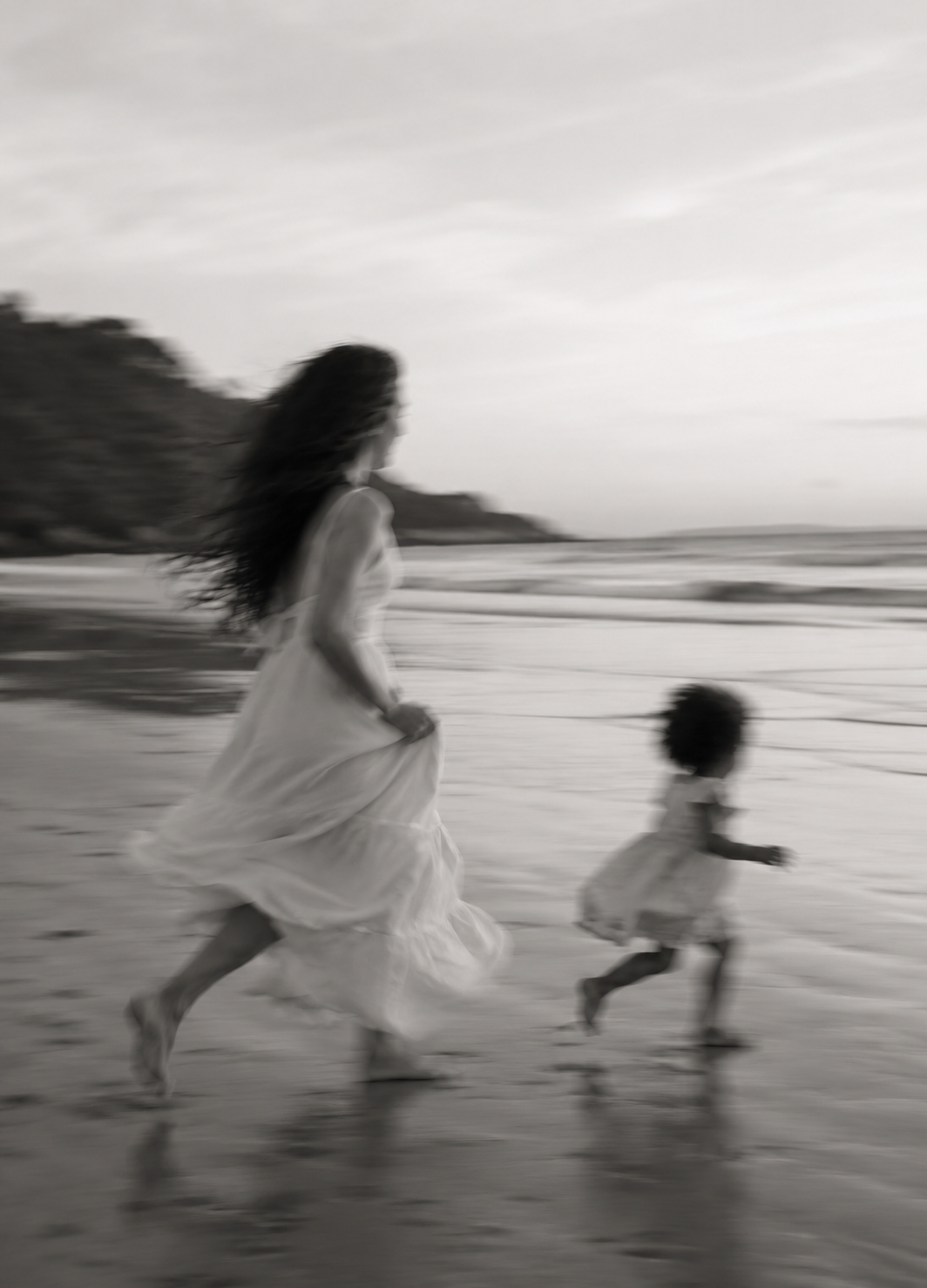 Mother and child running on the beach in black and white